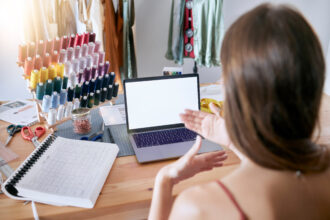 Rozmowa wideo na laptopie i spotkanie planistyczne projektanta mody w celu reklamy marketingu cyfrowego lub lokowania produktu na pustym ekranie Kreatywna kobieta konferencyjna online i stylista pracujący przy biurku w studio